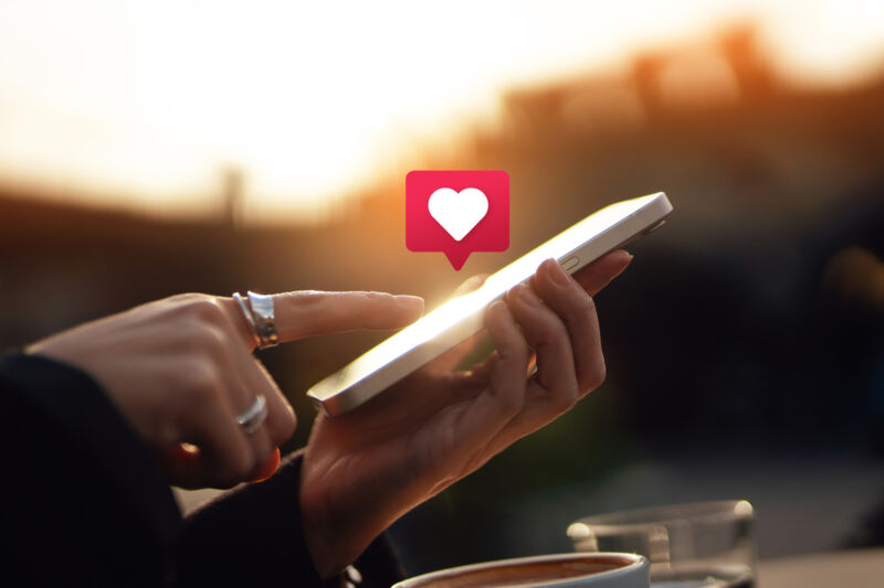 Young woman receiving notifications and commenting on social media posts with smart phone. People networking with technology. Social media addiction concept.